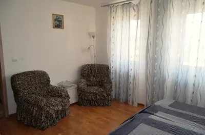 two chairs sitting in a room with a bed at Rezidence Jiskra in Brandýs nad Labem-Stará Boleslav
