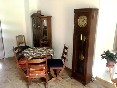 a dining room with a table and a grandfather clock at Rezidence Jiskra in Brandýs nad Labem-Stará Boleslav