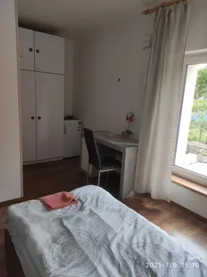 a bedroom with a bed and a desk and a window at Rezidence Jiskra in Brandýs nad Labem-Stará Boleslav