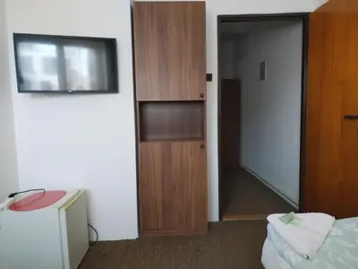 a room with a bed and a wooden cabinet at Pension Sparta in Prague