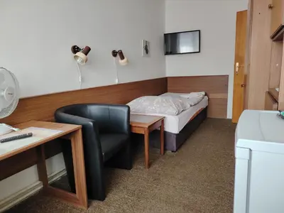 a room with a bed and a desk and a chair at Pension Sparta in Prague