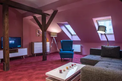 a living room with a couch and a tv at Spacious and Quiet Attic Flat in Centre in Prague