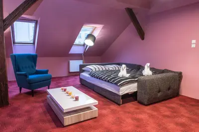 a living room with a couch and a chair at Spacious and Quiet Attic Flat in Centre in Prague