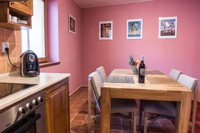 a kitchen with a wooden table with chairs around it at Spacious and Quiet Attic Flat in Centre in Prague