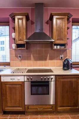 a kitchen with wooden cabinets and a stove top oven at Spacious and Quiet Attic Flat in Centre in Prague