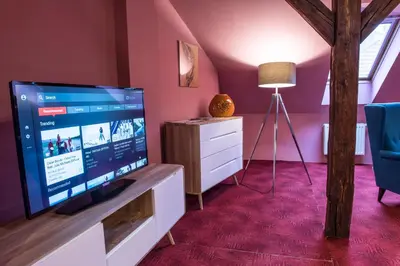 a living room with a large flat screen tv on a stand at Spacious and Quiet Attic Flat in Centre in Prague