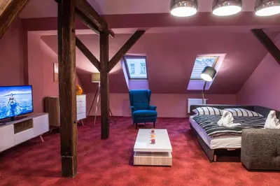 a living room with a couch and a tv at Spacious and Quiet Attic Flat in Centre in Prague