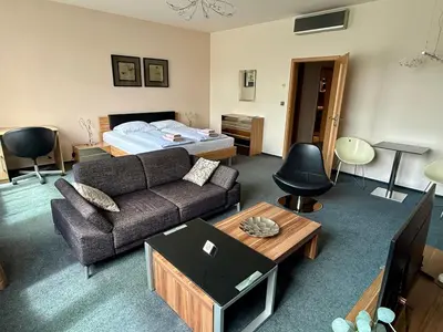 a living room with a couch and a bed at Pension Milk Inn in Prague