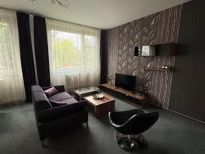 a living room with a couch and a tv at Pension Milk Inn in Prague