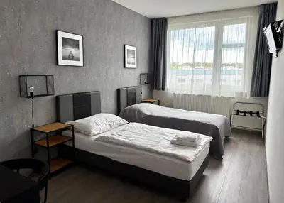 a bedroom with two beds and a window at Pension Milk Inn in Prague