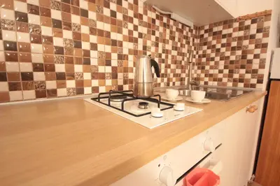 a kitchen with a stove and cups on a counter at Gallery Apartment in Prague