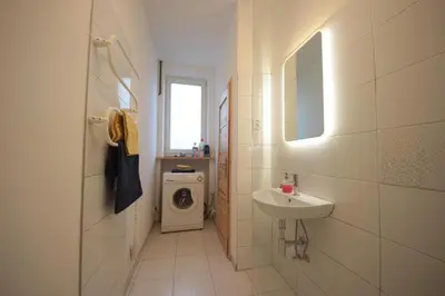 a bathroom with a sink and a washing machine at Gallery Apartment in Prague
