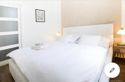 a white bed with white sheets and pillows at Romantic Apartment Petra - free parking Friday-Sunday in Prague