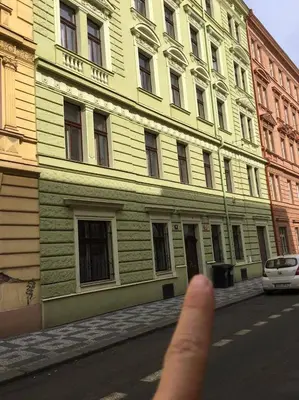 a persons thumb is pointing at a building at Romantic Apartment Petra - free parking Friday-Sunday in Prague