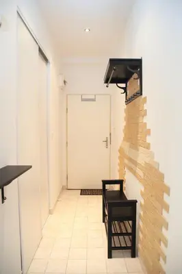 a hallway with a black chair next to a brick wall at Old Town studio in Prague