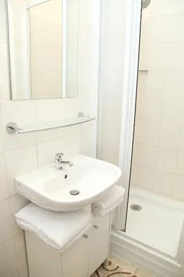a white bathroom with a sink and a shower at Old Town studio in Prague