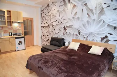 a bedroom with a large bed and a chair at Old Town studio in Prague