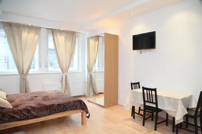 a bedroom with a bed and a table and a television at Old Town studio in Prague
