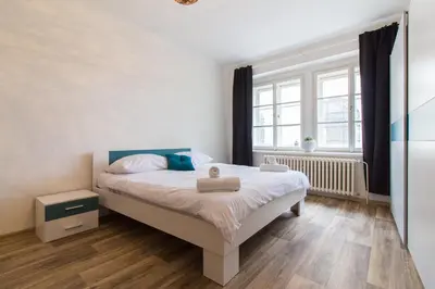 a bedroom with a white bed and a window at Karlova Apartment in Prague