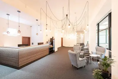 an office lobby with a reception desk and chairs at Narodni Stay in Prague