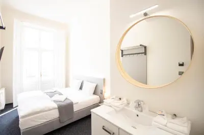 a bedroom with a bed and a mirror and a sink at Narodni Stay in Prague