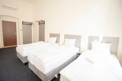 two beds in a hotel room with white sheets at Narodni Stay in Prague