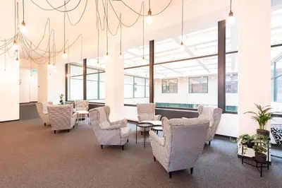 a waiting room with chairs and tables and windows at Narodni Stay in Prague