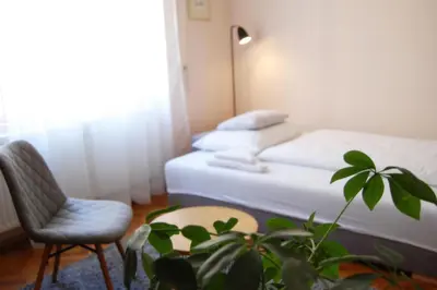 a bedroom with a bed and a chair and a plant at Apartment in the heart of Prague in Prague
