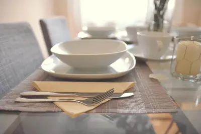 a wooden table with a plate and a bowl and fork at Apartment in the heart of Prague in Prague