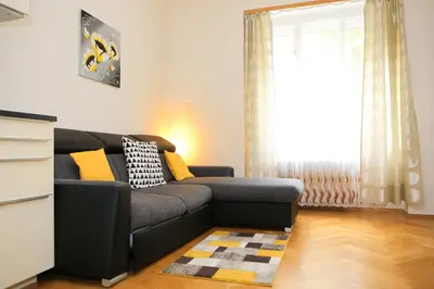 a living room with a couch and a window at Yellow apartment few steps from metro in Prague