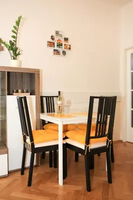 a dining room table with two chairs and a white table at Yellow apartment few steps from metro in Prague