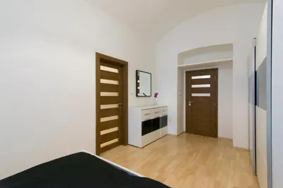a bedroom with two wooden doors and a fireplace at Spacious apartment near Wenceslas Square in Prague