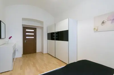 a bedroom with white cabinets and a wooden floor at Spacious apartment near Wenceslas Square in Prague