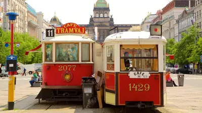 two trolley cars parked next to each other on a street at Spacious apartment near Wenceslas Square in Prague
