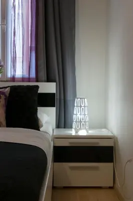 a bedroom with a bed and a window with a lamp at Spacious apartment near Wenceslas Square in Prague