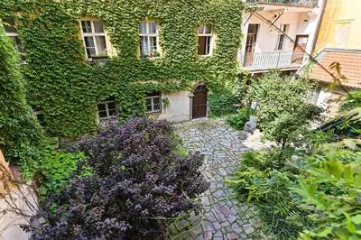 an ivycovered building with a garden in front of it at Apartment Nebovidy I - Historic centre - Terrace - Air Conditioning in Prague