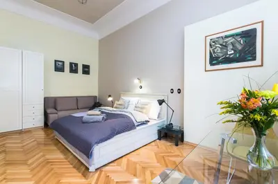 a bedroom with a bed and a vase of flowers at Apartment Nebovidy I - Historic centre - Terrace - Air Conditioning in Prague