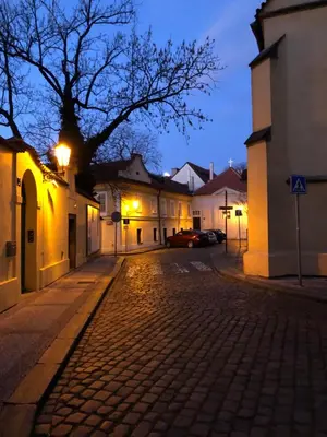 a cobblestone street in a town at night at Old Town Basement in Prague