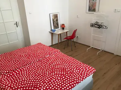 a bedroom with a red bed with polka dots at Old Town Basement in Prague