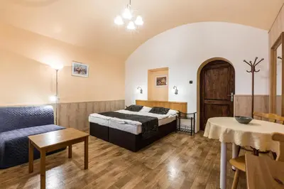a bedroom with a bed and a table and a couch at Mila Apartments in Prague