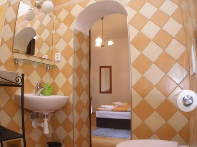 a bathroom with a sink and a toilet and a bedroom at Mila Apartments in Prague