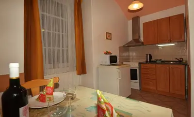 a kitchen with a table with a bottle of wine at Mila Apartments in Prague