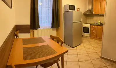 a kitchen with a wooden table and a refrigerator at Mila Apartments in Prague