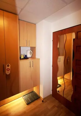 a room with a kitchen with wooden cabinets and a door at Hotel Garni Rambousek in Prague
