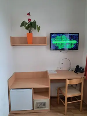 an office with a desk and a tv on a wall at Hotel Garni Rambousek in Prague