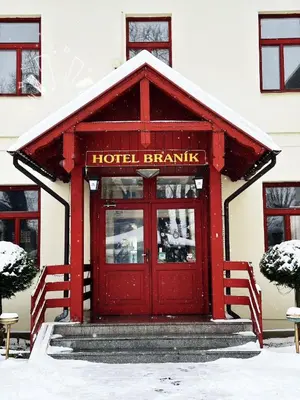a hotel branch with a red door in the snow at Hotel Braník in Prague