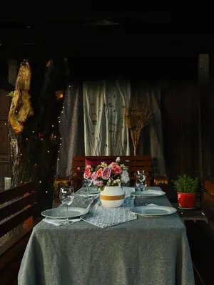 a table with a vase of flowers and wine glasses at Hotel Braník in Prague