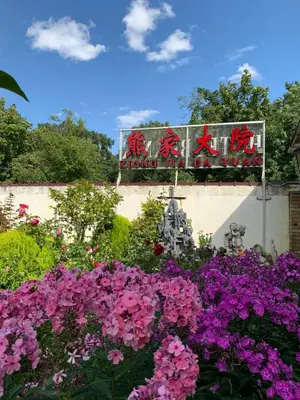 a garden of flowers with a sign in the background at Hotel Braník in Prague