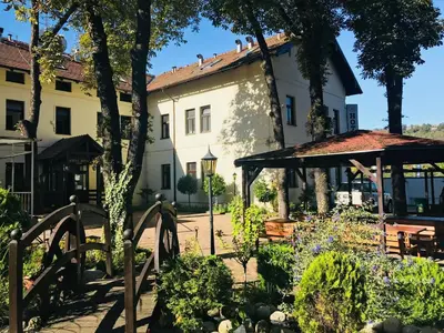 a garden in front of a building with a gazebo at Hotel Braník in Prague