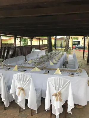 a row of tables with white chairs and bows at Hotel Braník in Prague